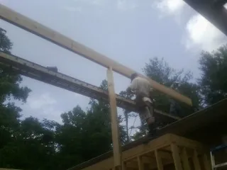 Carpenter setting a ridge beam over a new addition frame — Ice Dam Removal by Roofing Brothers in Diamond Bar