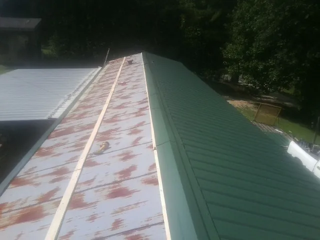 Old rusted panels beside newly installed green metal roofing — Wind Damage Roof Repair by Roofing Brothers in Diamond Bar